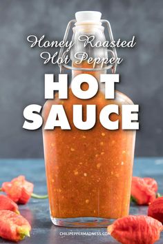 hot sauce in a glass bottle with the words honey roasted chili pepper on it and red peppers scattered around