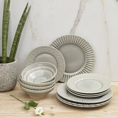 a table topped with plates next to a potted plant