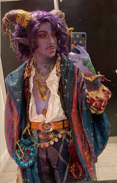 a man with purple hair is dressed in costume and holding a cell phone to his ear