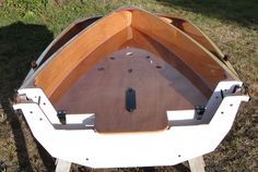 a wooden boat sitting on top of a grass covered field