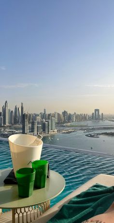 a bowl sitting on top of a table next to a pool in front of a city