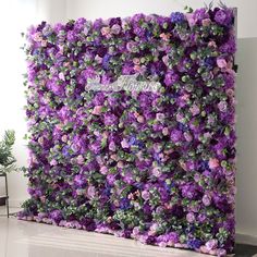 purple flowers are growing on the side of a wall in an empty room next to a potted plant