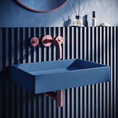 a blue sink sitting next to a wall mounted faucet