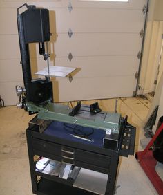 a machine that is sitting on top of a shelf in a garage with other tools