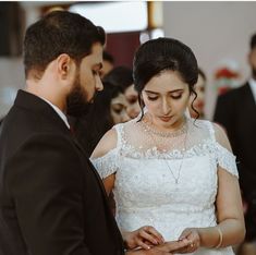 a man and woman standing next to each other in front of a group of people