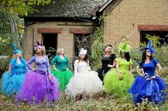 a group of women dressed in costume standing next to each other near a brick building