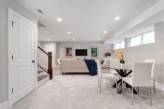 a living room filled with furniture and a dining table in front of a doorway that leads to another room