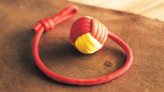 a red rope with a yellow ball on it