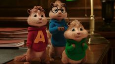 the chipmuns are dressed in sweaters and standing next to each other on a television screen