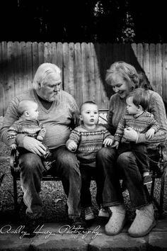 black and white photograph of an old family sitting on a bench with their baby boy