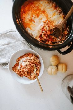 a bowl of pasta and some bread on a table