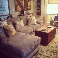 a living room filled with lots of furniture and pillows on top of a carpeted floor