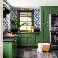 a kitchen with green cabinets and tile flooring