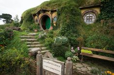 a green hobbot house with steps leading up to it