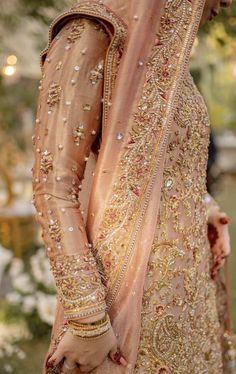 a woman in a bridal gown is standing outside