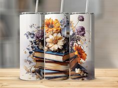 three books are stacked on top of each other with flowers and leaves painted on them