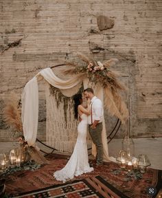 a bride and groom standing in front of a decorated wall