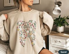 a woman wearing a sweatshirt with an image of a tooth on it