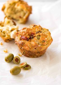 three muffins with olives and cheese on the side