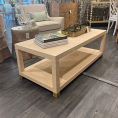 a coffee table with books on it in a room filled with furniture and decor items