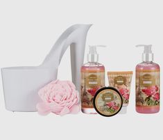 the body care products are arranged in front of a white vase with pink flowers on it