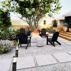 a fire pit surrounded by black chairs and trees