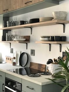 the kitchen is clean and ready to be used for cooking or baking, with shelves on the wall above the stove