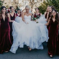 a group of women standing next to each other wearing dresses and holding bouquets in their hands