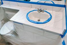 a white sink with blue tape around it