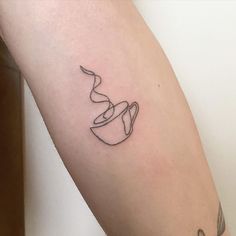 a tattoo on the arm of a woman with a coffee cup and saucer in it