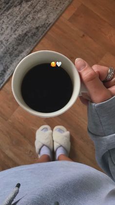 a person holding a cup of coffee in their hand