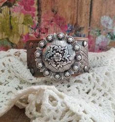 "v'¯) .`*.¸.*' ★ ★ Beautiful RuStiC leather bracelet, always with a FeMiNinE flair ❤ ¸.*'.*'¨) ¸. (¸.*'(¸.*' (¸. Simply gorgeous color combo! This DESIGN ❤~ The natural leather floral embossed cuff was painted silver over bronze, then distressed and sealed. A large beautiful intricate antique silver floral concho sits centered. Rivets were set individually into the leather. The width of the cuff is approximately 1 1/4\" wide. BRACELET SIZING INFO: My women's bracelets are approximately 8 1/2 inc Adjustable Western Cuff Bracelet For Festivals, Adjustable Western Style Cuff Bracelet For Festivals, Adjustable Western Style Festival Cuff Bracelet, Western Style Adjustable Cuff Bracelet For Festivals, Vintage Hand Tooled Bracelets For Festivals, Western Concho Bracelets For Festival, Vintage Hand Tooled Cuff Bracelet For Festivals, Vintage Hand-tooled Cuff Bracelet For Festivals, Western Style Concho Bracelets For Festivals