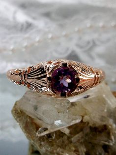 Natural Amethyst Ring Description  Floral Wedding Design#154 Made To Order High quality natural amethyst gemstone solitaire is the star of this beautiful Victorian/Edwardian reproduction wedding ring. Crafted in sterling silver and plated with rose gold, this ring features a full cut round amethyst with a diameter of 4mm. The delicate filigree setting in rose gold adds an elegant floral touch to this antique-inspired design. The inside of the band is marked with 925 for sterling silver authenticity. This ring is a perfect choice for a unique and romantic engagement ring or a special gift for a loved one. Each ring comes with a gift box for safekeeping. If you have any questions, please feel free to reach out. Thank you for visiting my store. Suggested Retail $149+ Natural Amethyst Ring Des Filigree Amethyst Ring For Wedding, Antique Amethyst Ring With Intricate Design, Amethyst Filigree Ring, Gold Amethyst Jewelry With Filigree Detail, Purple Amethyst Filigree Ring, Engagement Rings Romantic, Luxury Jewelry Box, Wedding Leaves, Amethyst Gem