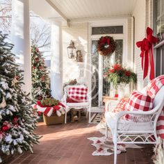 a porch decorated for christmas with red and white decorations