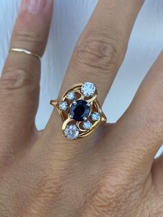 The genuine blue sapphire measures approximately 6mm x 5mm for approximately .75ct.  It is surrounded by 6 very sparkly round diamonds of approximately .58ctw G-H/SI1-I2.   Ring weighs 5.2g and measures 17mm at its widest point. It is stamped 14K yellow gold. It is currently a size 7.5 and fully sizable.  We are happy to provide sizing for an additional charge.  Let me know if you need a quote. Ring Engagement, Cocktail Ring, Cocktail Rings, Rings Statement, Ring Verlobung, Round Diamond, Blue Sapphire, Round Diamonds, Statement Rings