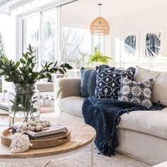 a living room filled with furniture and lots of plants on top of a coffee table