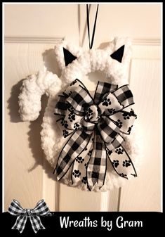 a wreath with a dog's paw print on it hanging from the front door