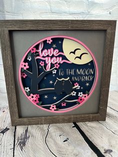 a wooden frame with a paper cut out of the moon and tree