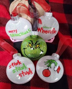 christmas ornaments with grin face on them are sitting on a red and black checkered blanket