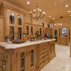 a large kitchen with chandelier and marble counter tops in an upscale style home