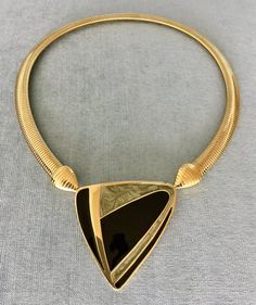 You are looking at a truly exquisite VINTAGE TRIFARI MODERNIST, ART DECO STYLE, KUNIO MATSUMOTO ERA, BLACK and SILVER-COLOURED ENAMEL AND GOLD METAL OMEGA SNAKE CHAIN PENDANT COLLAR NECKLACE, SIGNED, Circa 1980's.THIS COLLAR NECKLACE IS EXTREMELY BOLD, EYE-CATCHING AND GORGEOUS!!!SUPER RARE!!! MINT, IN EXCELLENT, LIKE NEW CONDITION, IT HAS NEVER BEEN USED!!!THIS NECKLACE WITH AN ART DECO INSPIRED BLACK AND SILVER ENAMEL STATION AND SUPER SHINY OMEGA CHAIN IS EXTRAORDINARILY BEAUTIFUL AND SCULPTU Designer Yellow Gold Evening Necklace, Designer Yellow Gold Necklaces For Evening, Designer Yellow Gold Necklace For Evening, Designer Gold Necklaces For Evening, Elegant Evening Necklaces With Black Enamel, Elegant Evening Necklace With Black Enamel, Elegant Black Enamel Necklaces For Evening, Elegant Evening Black Enamel Necklaces, Designer Metal Necklaces For Formal Occasions