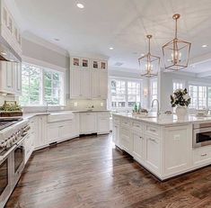 a large kitchen with white cabinets and an island in the middle of the room is shown