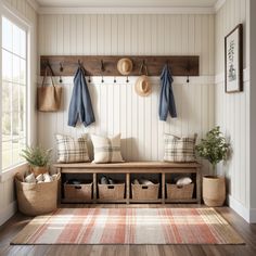 a wooden bench sitting next to a window filled with baskets and coats hanging on the wall