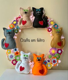 a wreath made out of felt with cats and flowers in the shape of a heart