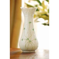 a white vase sitting on top of a wooden table