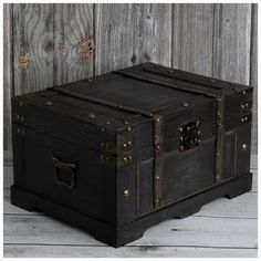 an old trunk sitting on top of a wooden floor next to a wood plank wall