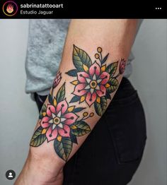 a woman's arm with flowers and leaves tattooed on the side of her arm