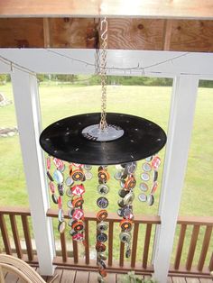 a wind chime hanging from a porch in front of a window with lots of buttons on it