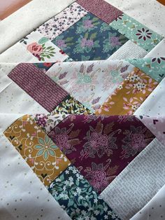 a close up view of a quilt with many different colors and patterns on the fabric