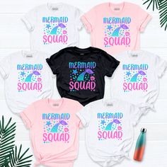 the mermaid squad shirts are on display next to pineapples and water bottles,